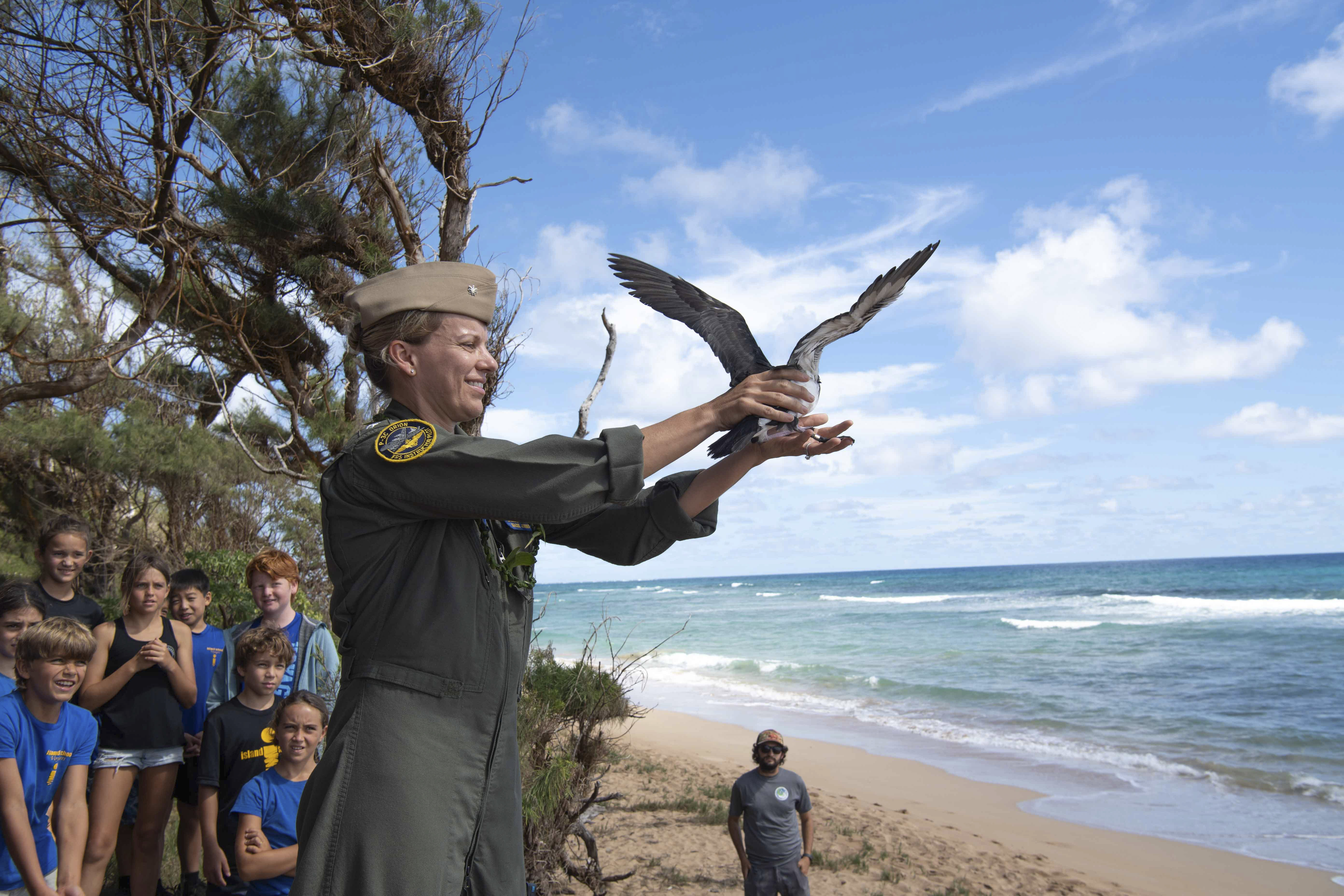 This is an image of the executive officer releasing a shearwater into the wild.